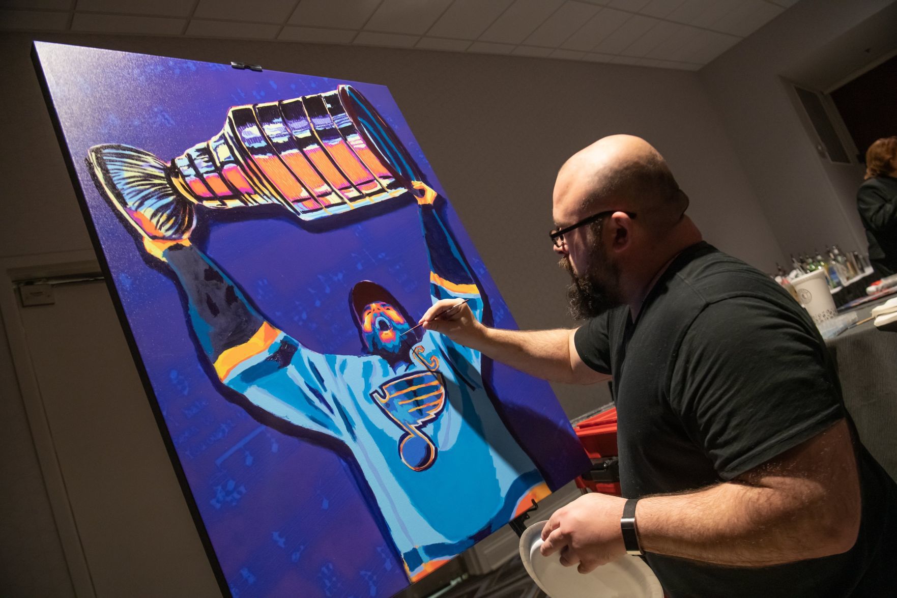 Steven Walden works on a painting of St. Louis Blues captain Alex Pietrangelo